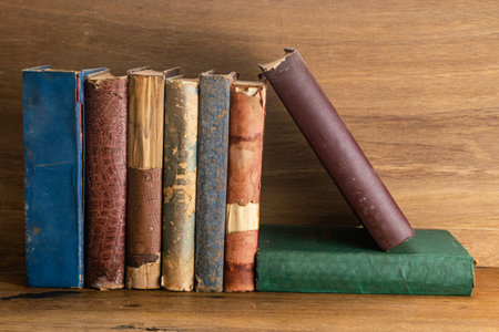 Stack of old grungy books on wooden background. Hardcover old and torn books on a table.の写真素材