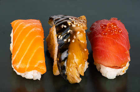 Closeup view of three kinds of fish sashimi sushi on dark background.  High angle view of Japanese seafood sushi on black.の写真素材