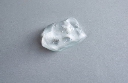 Top view smudge of cosmetic gel with bubble on white background. Moisturizer gel drops drip down on...