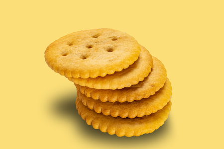 High angle view stack of salted round crackers isolated on yellow background with clipping path