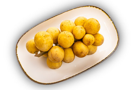 High angle view bunch of Long Kong, Longkong, Langsart in brown ceramic tray isolated on white...