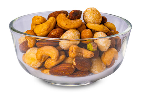 Closeup view of crispy salted mixed nuts in transparent glass bowl isolated on white background.の写真素材