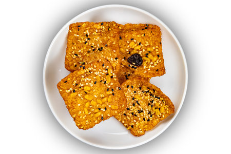 Top view of square shape bars of crispy homemade multigrain  rice cracker in white ceramic dish...