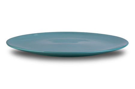 Side view of empty shallow blue ceramic plate isolated on white background with clipping path.の写真素材