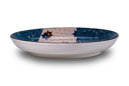 Side view of empty blue and brown star pattern dark edge ceramic plate isolated on white background with clipping path.の写真素材