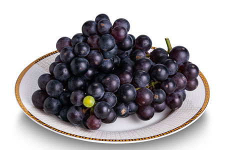 High angle view bunch of ripe black wine grape in white ceramic dish isolated on white background with clipping path.の写真素材
