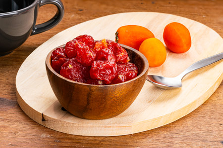 Dehydrated cherry tomatoes or sun dried cherry tomatoes or Solanum lycopersicum var. cerasiforme in wooden bowl with metal spoon on wooden cutting board.の写真素材