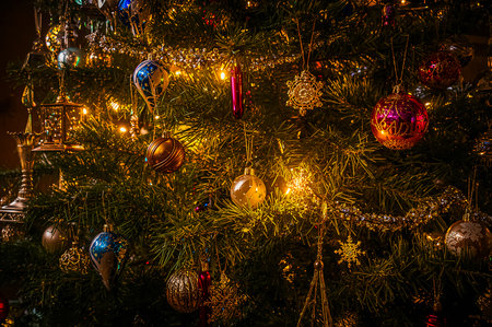 Closeup view of illuminated Christmas tree with colorful glittering ornaments decorative in a house in the winter. Generated AI.の素材