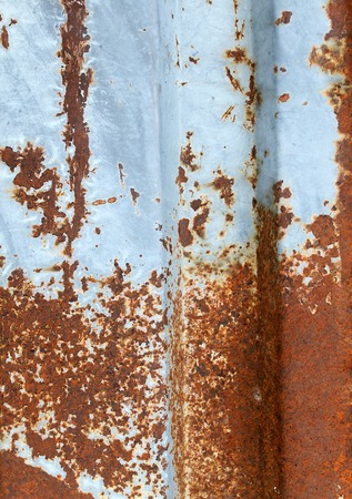 Multicolored background: rusty metal surface with blue paint flaking and cracking textureの写真素材