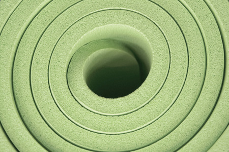 Green yoga mat rolled upの写真素材