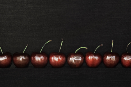 Eight cherries varieties Bull's eye on black fabric background subtextの写真素材