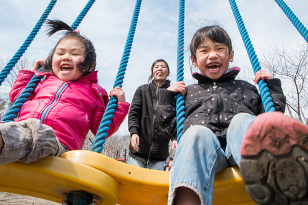 Parents and children playing on the swingの写真素材