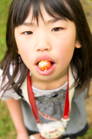 Girl eating cherriesの写真素材