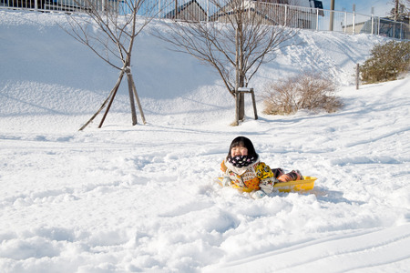 Children lie on the sledの写真素材