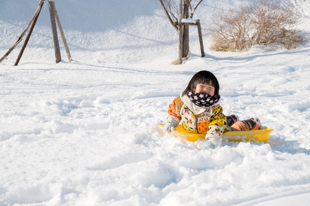 Children lie on the sledの写真素材