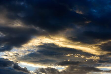 Sun shines through the rain clouds were gathering in the evening.の写真素材