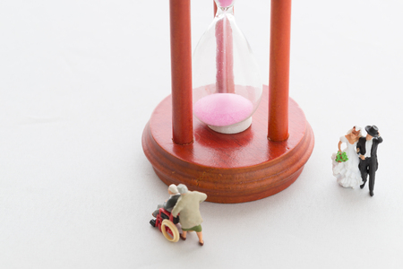 A hourglass and a newly-married couple and seniorの写真素材