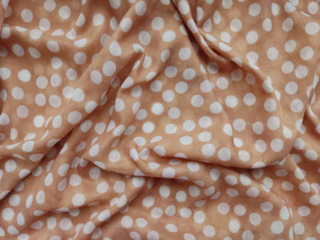 Beige delicate natural background for cosmetics and beauty fabric fashionable textile dotted with...