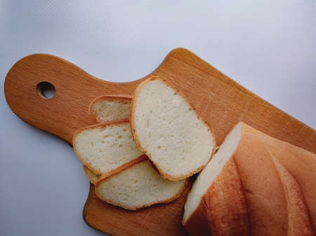 loaf of white bread thinly sliced on a wooden board close upの写真素材