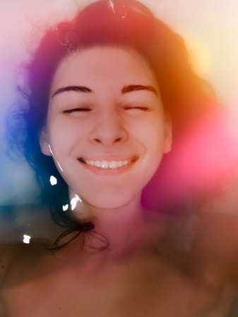 woman in bath cute smiling in water. bathes relaxesの写真素材