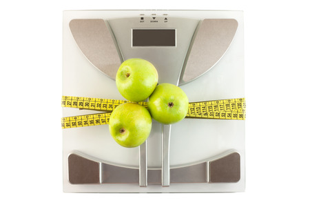 Scale with a measuring tape and apple, weight loss conceptの写真素材