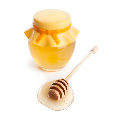 honey dipper and honey in jar on white backgroundの写真素材
