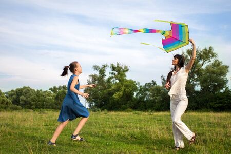mother and daughter flying a kiteの写真素材
