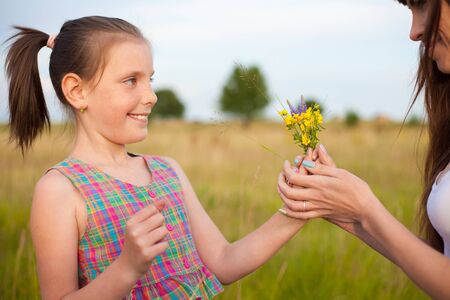Daughter giving mother flowersの写真素材