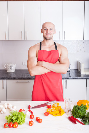 muscle man cooking in the kitchenの写真素材