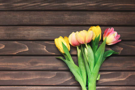 colorful tulips over wooden table backgroundの写真素材