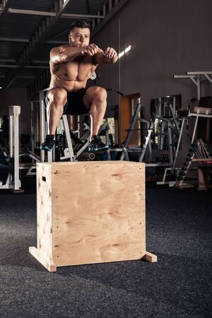 Man box jumping at a crossfit style gym.の写真素材