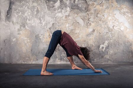 Young man practicing yoga in a urban backgroundの写真素材
