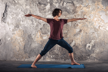 Man doing yoga exercises. Practicing yoga in a urban backgroundの写真素材