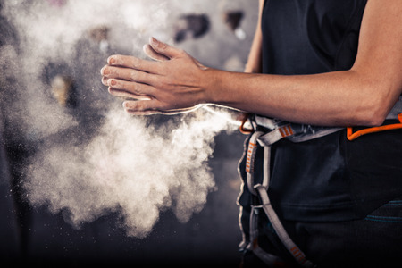 Climber woman coating her hands in powder chalk magnesium and preparing to climb indoor, close-upの写真素材