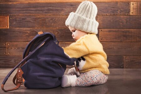 Little baby with backpack is  being prepared for traveling