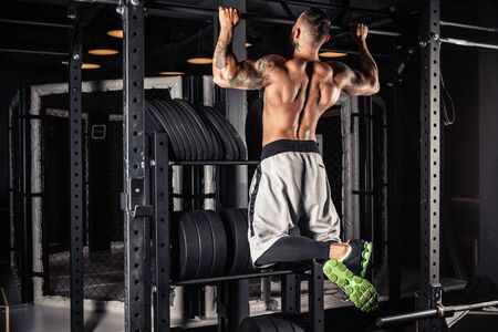 Strong man doing pull ups in gymの写真素材