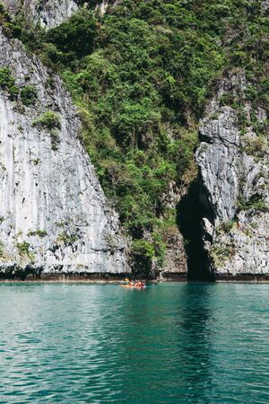 Tourists on a kayak  in front of the big rock in the tropics. Vacation holiday activityの写真素材