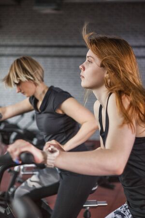 Sportive people while cardio training in gym.