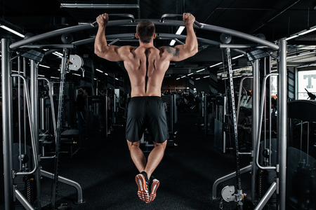 Back view of muscular man doing pull up exerciseの写真素材
