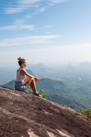 Young woman traveler  hiking in the mountains, relaxing and enjoying a beautiful nature during vacation .の写真素材