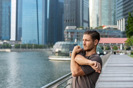 Sport young man stretching arms outdoors