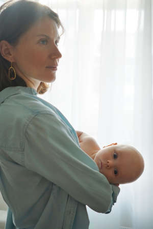 Mother with baby standing at home
