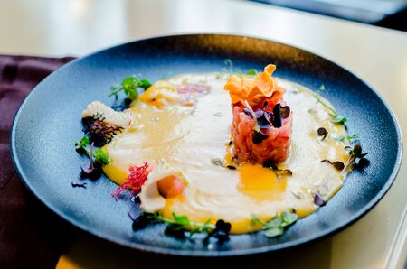 tar-tar from tuna. Tuna in pumpkin sauce with herbs and seafood on a plate.の写真素材