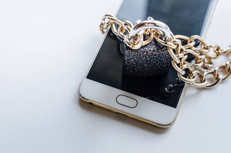 Blocked smartphone. The smartphone is chained and locked, as a symbol of private access to software.の写真素材