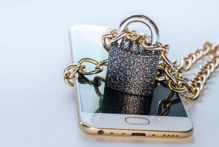 Blocked smartphone. The smartphone is chained and locked, as a symbol of private access to software.の写真素材