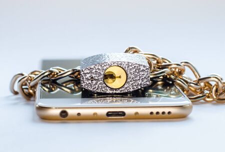Blocked smartphone. The smartphone is chained and locked, as a symbol of private access to software.の写真素材