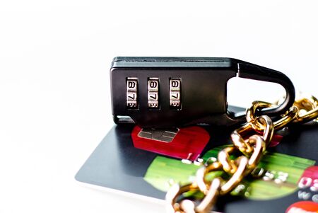 A blocked bank card. Credit card account is blocked. It is not possible to make transactions on the card. Credit cards in the chain and under lock and key.の写真素材