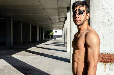 Athletic guy with a naked torso and blindfolded eyes.
