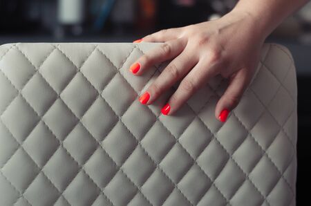 The back of a leather chair with a hand lying on itの写真素材