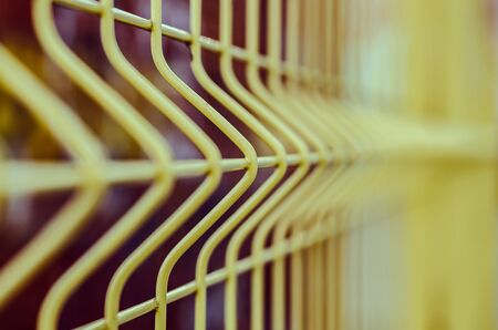 Closeup photo of a yellow iron fenceの写真素材
